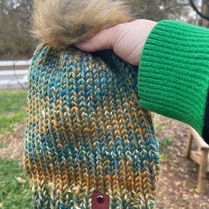 Hand knit beanie with a faux fur pom pom